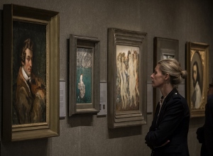 woman looking at Paintings hanging on wall