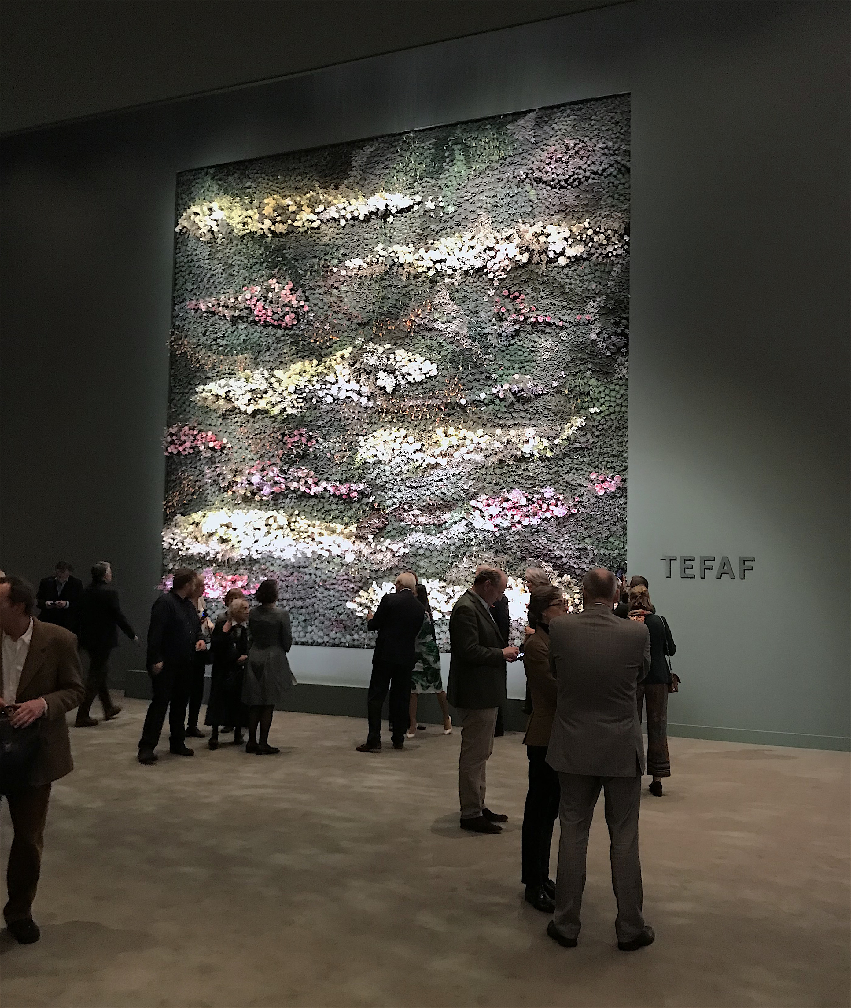 people viewing painting in art gallery